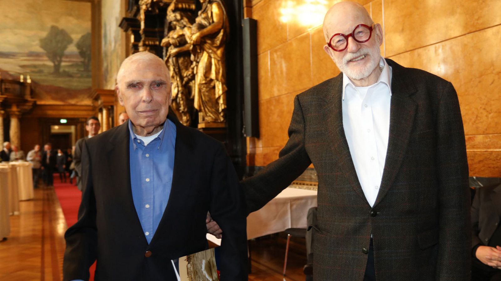Recién casados, Alfred Kaine y John Guenther caminan sonriendo después de la ceremonia