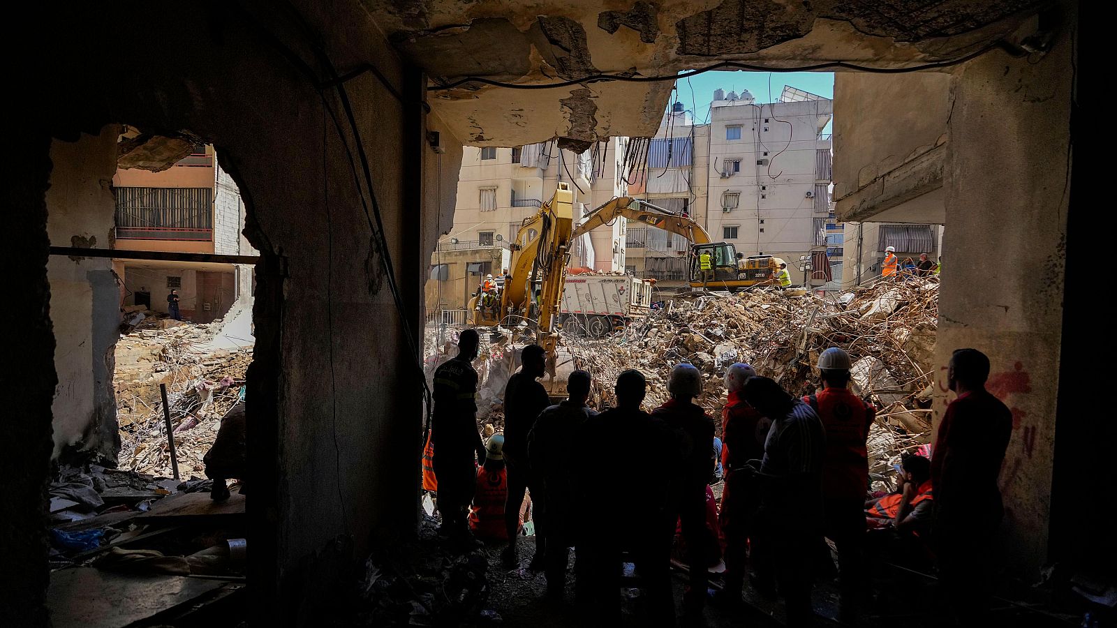 Trabajadores de emergencias utilizan excavadoras para retirar los escombros en el lugar del ataque israelí al sur de Beirut.