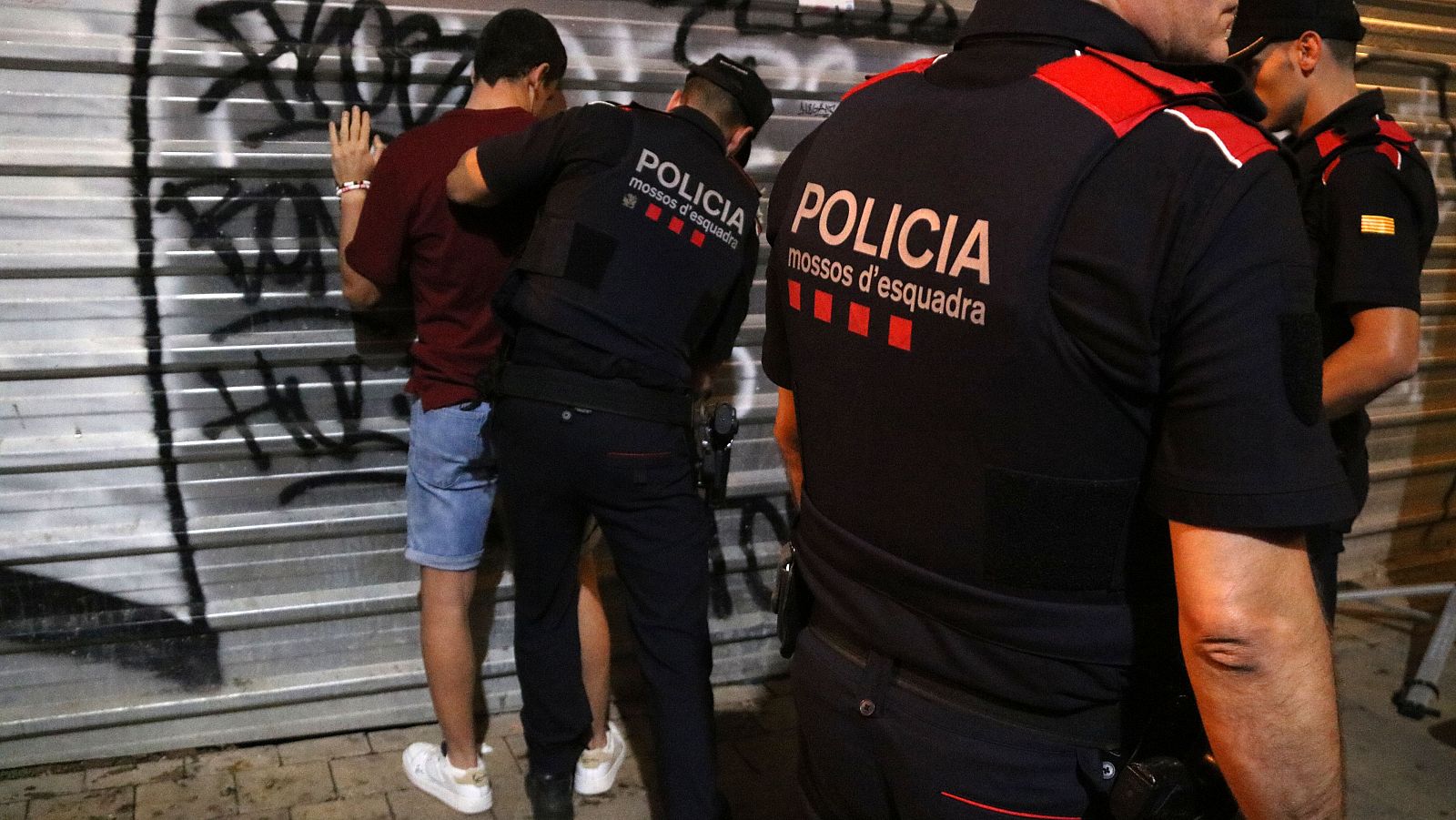 Els agents dels Mossos escorcollen un jove a les festes de Santa tecla (ACN | Anna Ferràs)
