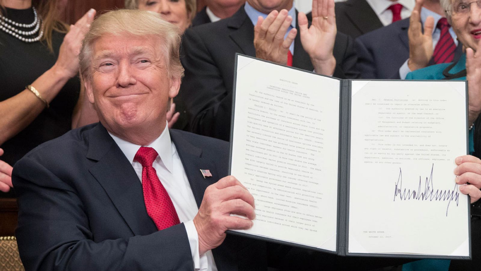 Trump posa tras firmar una orden ejecutiva diseñada para "aliviar" a los ciudadanos ante algunos requisitos de Obamacare