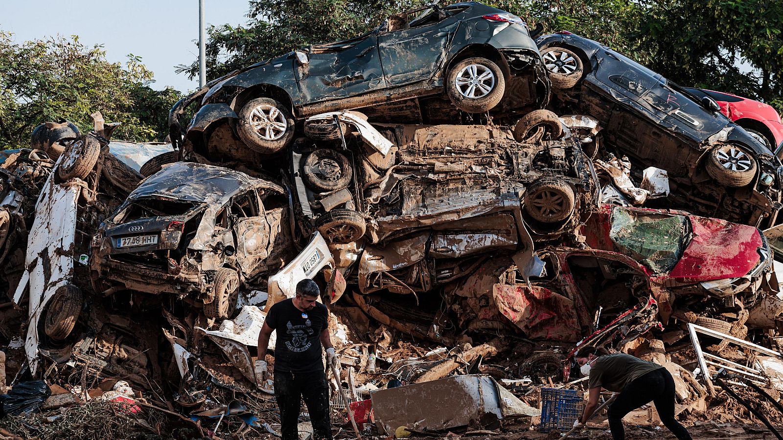 Varias personas limpian entre coches amontonados en Alfafar, a 5 de noviembre de 2024