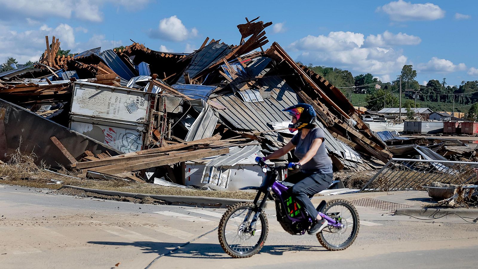 Devastación en Carolina del Norte: una persona en moto recorre una calle con edificios destruidos tras el huracán Helene.