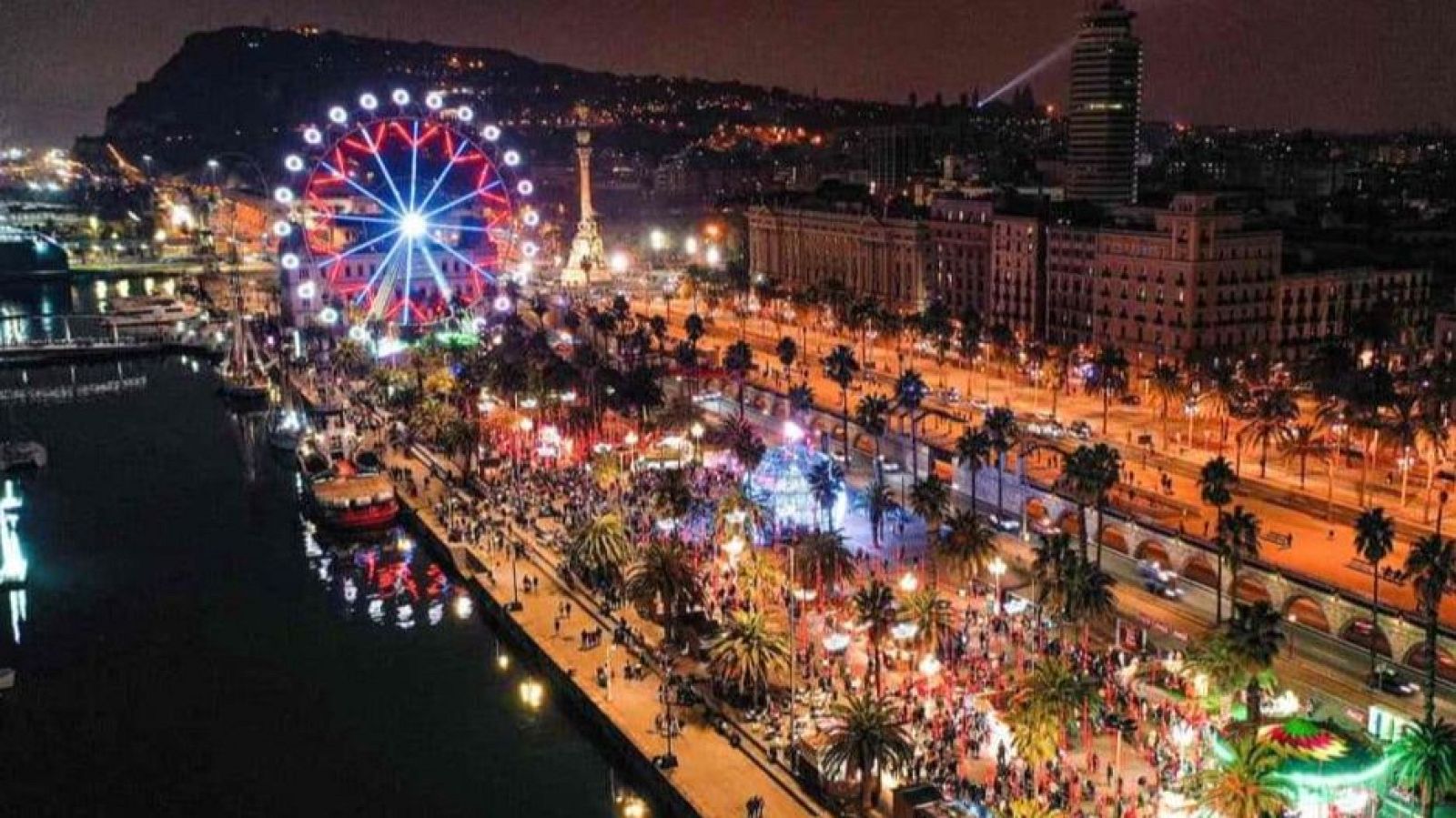 El Moll de la Fusta de Barcelona brilla con luces y ambiente navideño en esta vista nocturna.