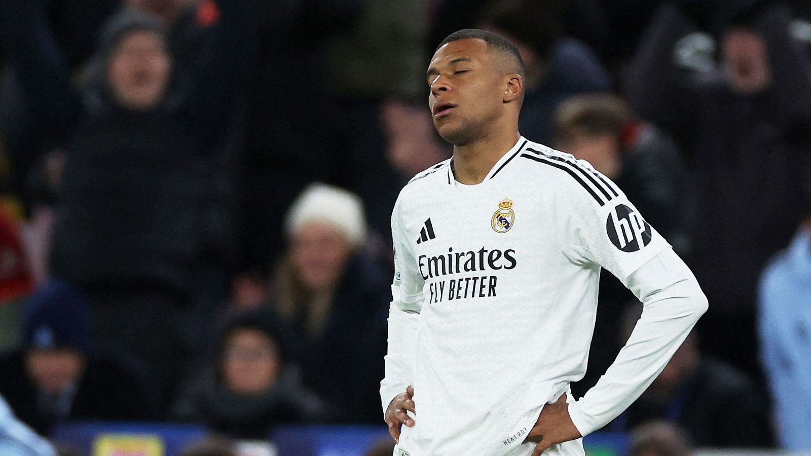 Mbappé del Real Madrid en Anfield, camiseta blanca con patrocinadores Emirates y HP. Expresión de cansancio.