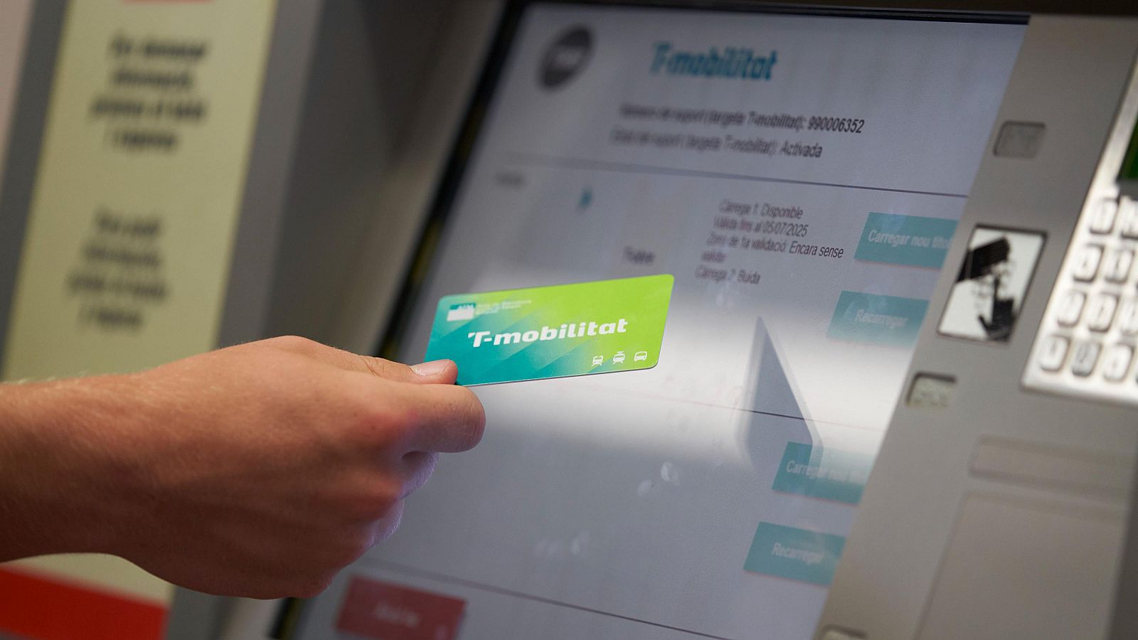 Tarjeta T-mobilitat acercándose a lector de máquina expendedora de metro.  Pantalla muestra información de la tarjeta, posiblemente estado 'Activada'.