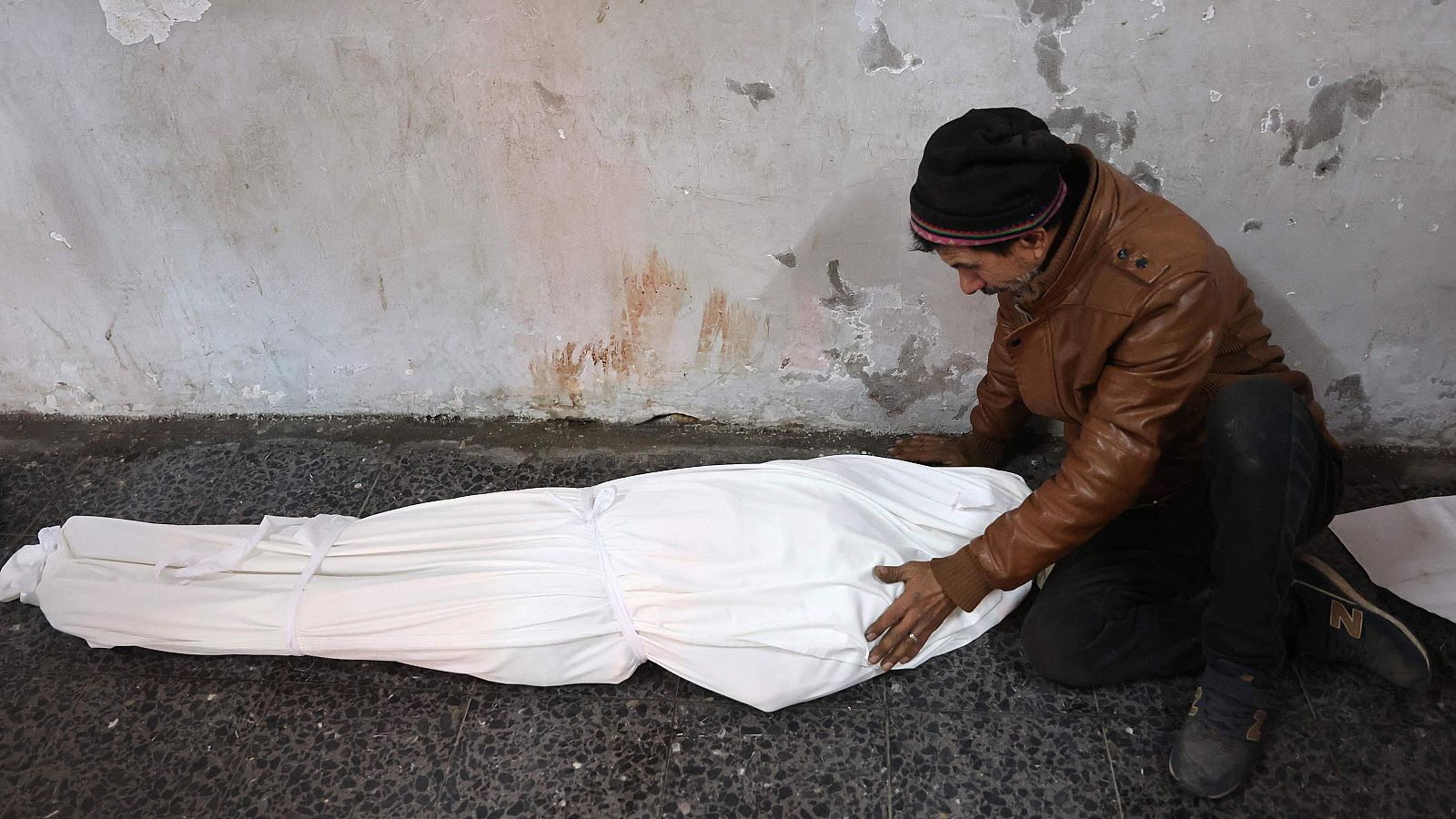 Un hombre llora ante el cuerpo amortajado de un familiar en el hospital árabe Al-Ahli, también conocido como hospital Bautista, en Gaza