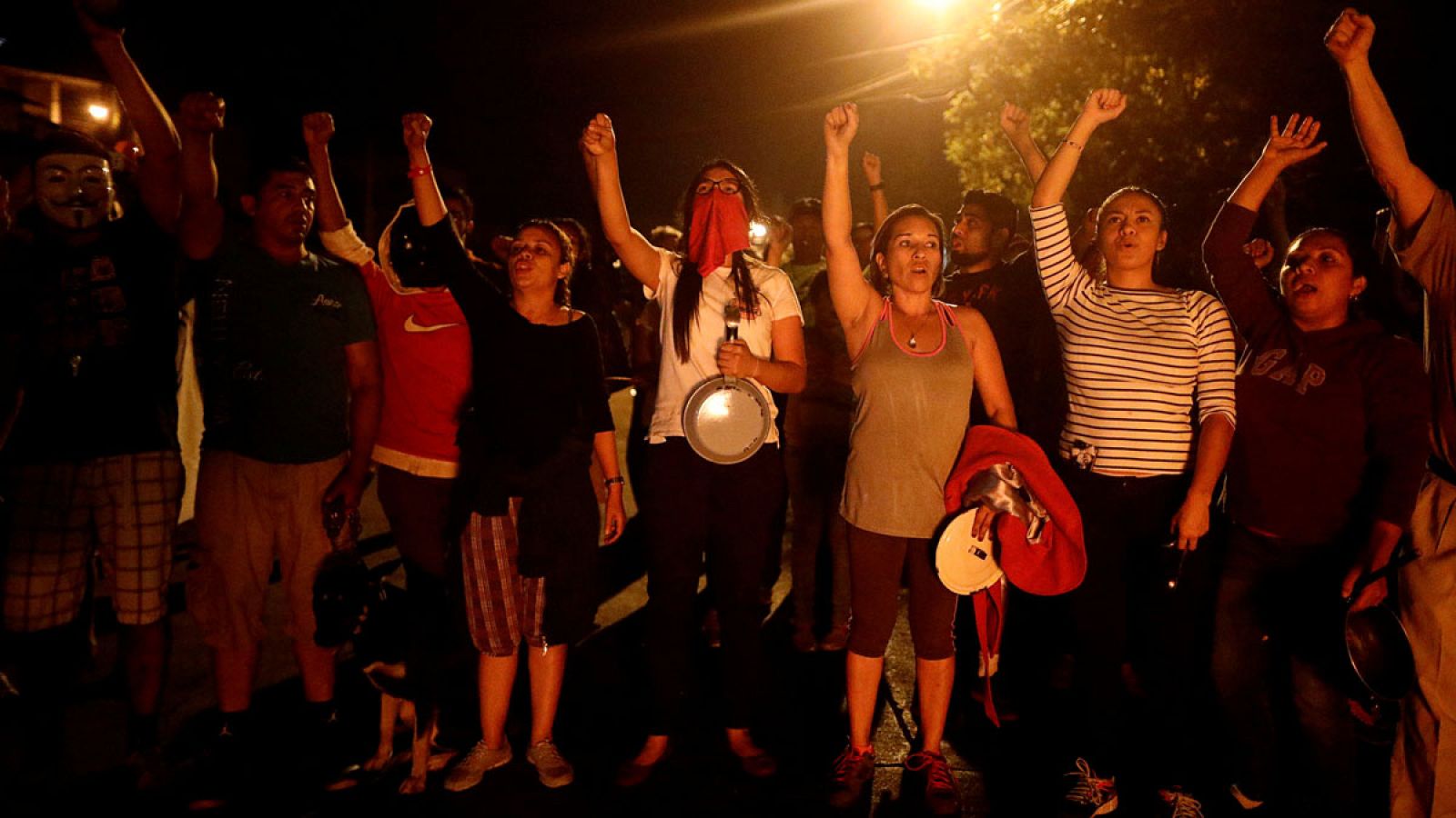 Partidarios del líder de la oposición hondureña, Salvador Nasralla, cantan el himno nacional durante el toque de queda