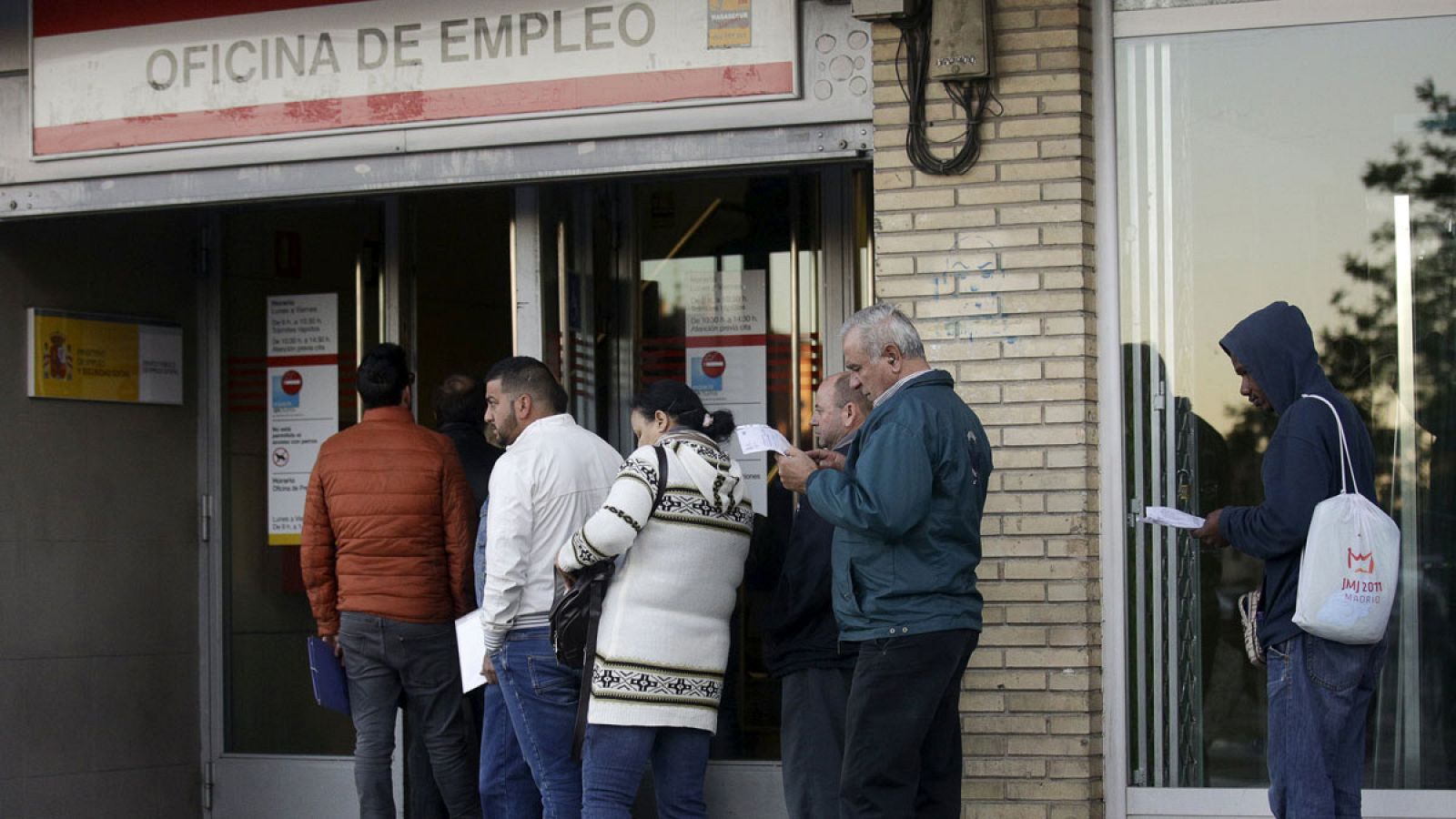 Varias personas esperan a que abra una oficina de empleo de Madrid