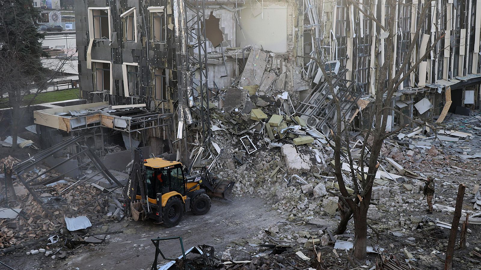 Una excavadora retira los escombros tras un ataque con misiles balísticos rusos en Izium, Ucrania