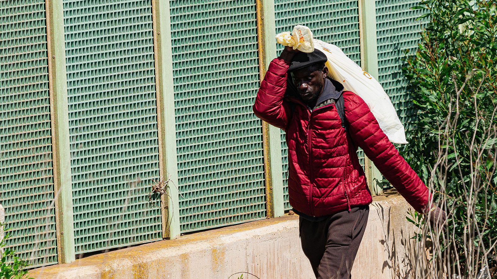 Inmigrante subsahariano carga sus pertenencias en un saco