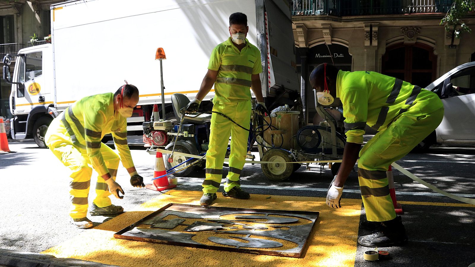 Treballadors a punt de pintar el senyal d'una bici al carrer de Pau Claris, a l'altura de Provença, a Barcelona | ACN
