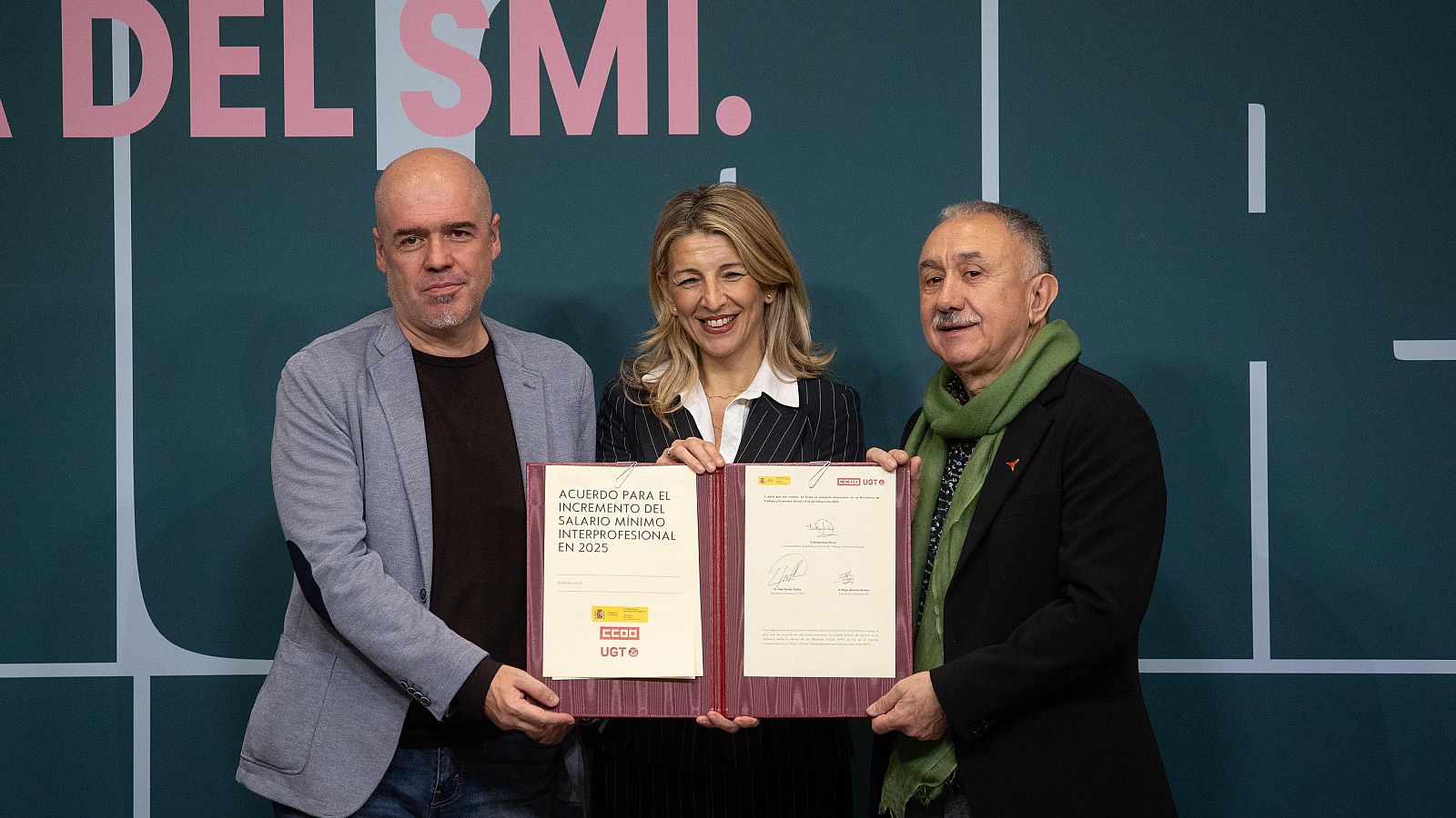 Acuerdo para la subida del SMI a 1184€ mensuales en 14 pagas, firmado por Yolanda Díaz con representantes de CCOO y UGT.  Se observa a tres personas sosteniendo el documento del acuerdo.