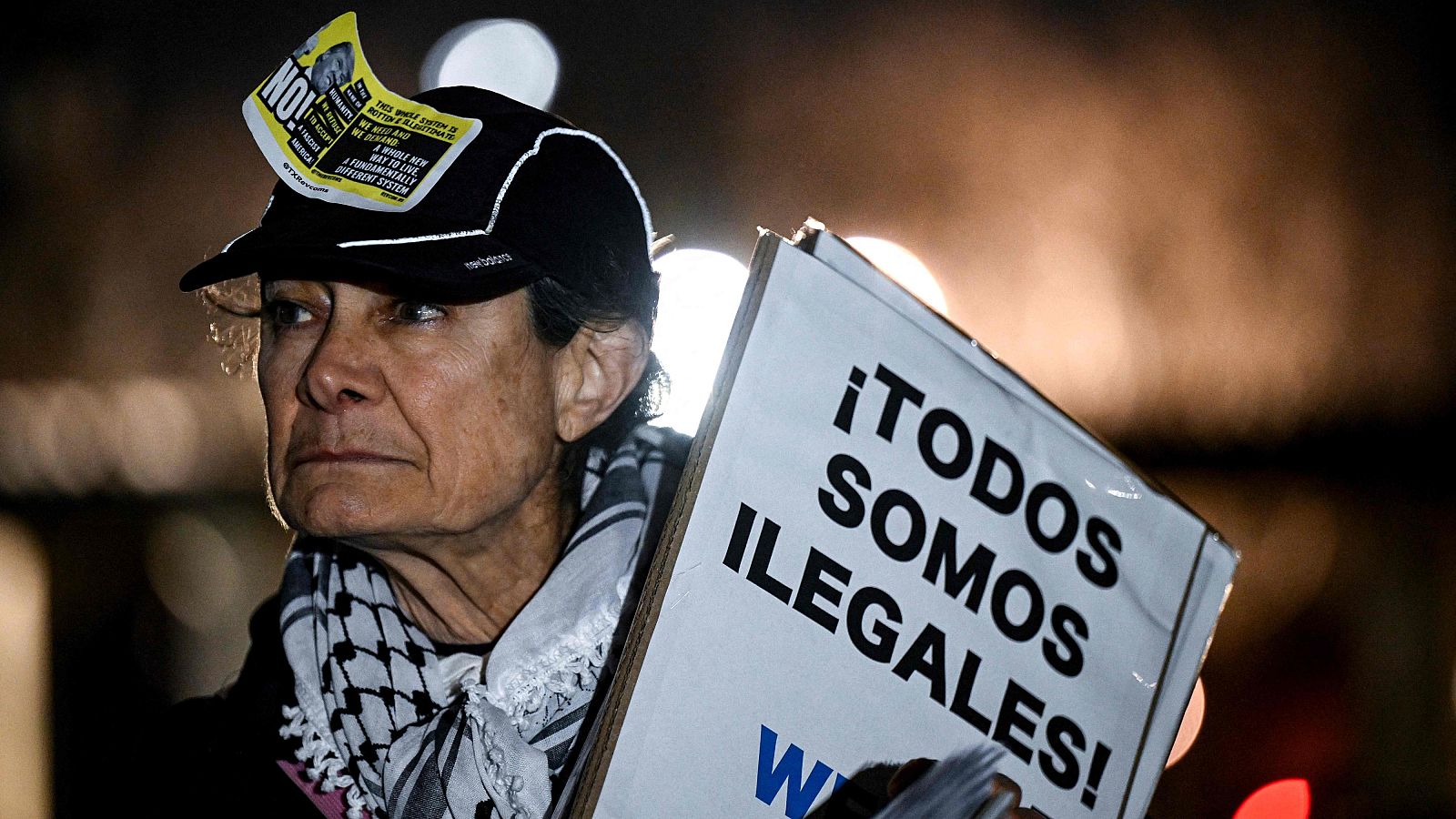 Una persona sostiene un cartel que dice "todos somos ilegales" durante una manifestación en Houston, Texas