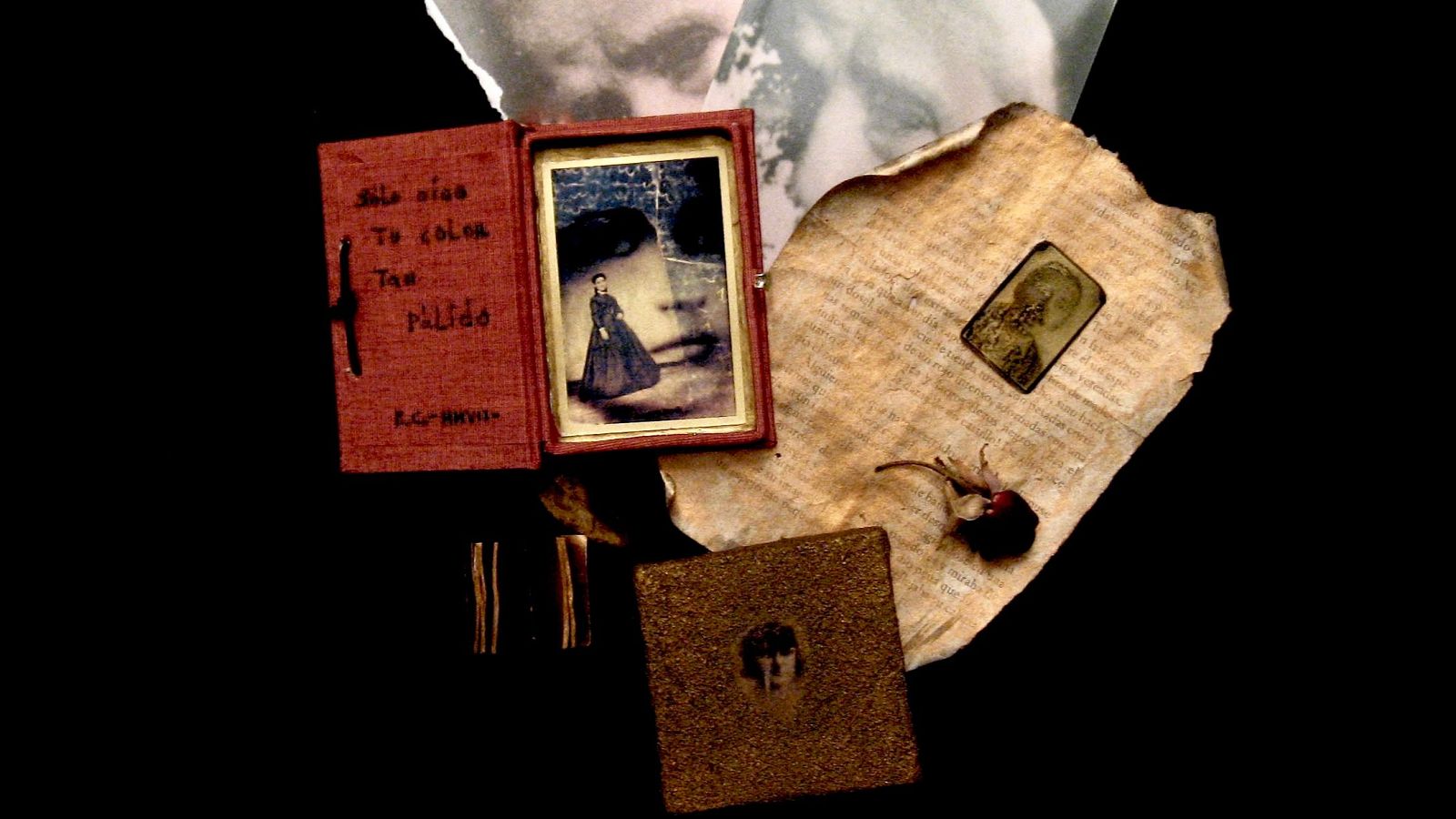 Composición nostálgica con libro rojo, foto antigua de mujer, papel envejecido y miniatura. Objetos pequeños y caja marrón añaden a la atmósfera melancólica.