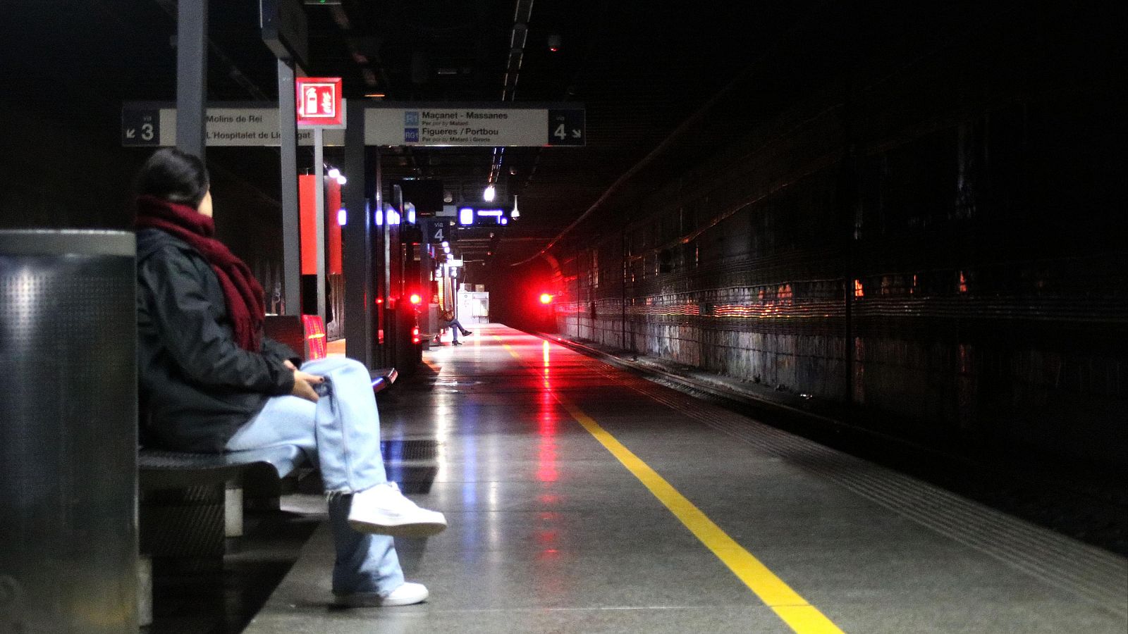 Una usuària espera a les andanes 3 i 4 de l'estació del Clot-Aragó, que es troba a les fosques aquest dilluns al matí | ACN