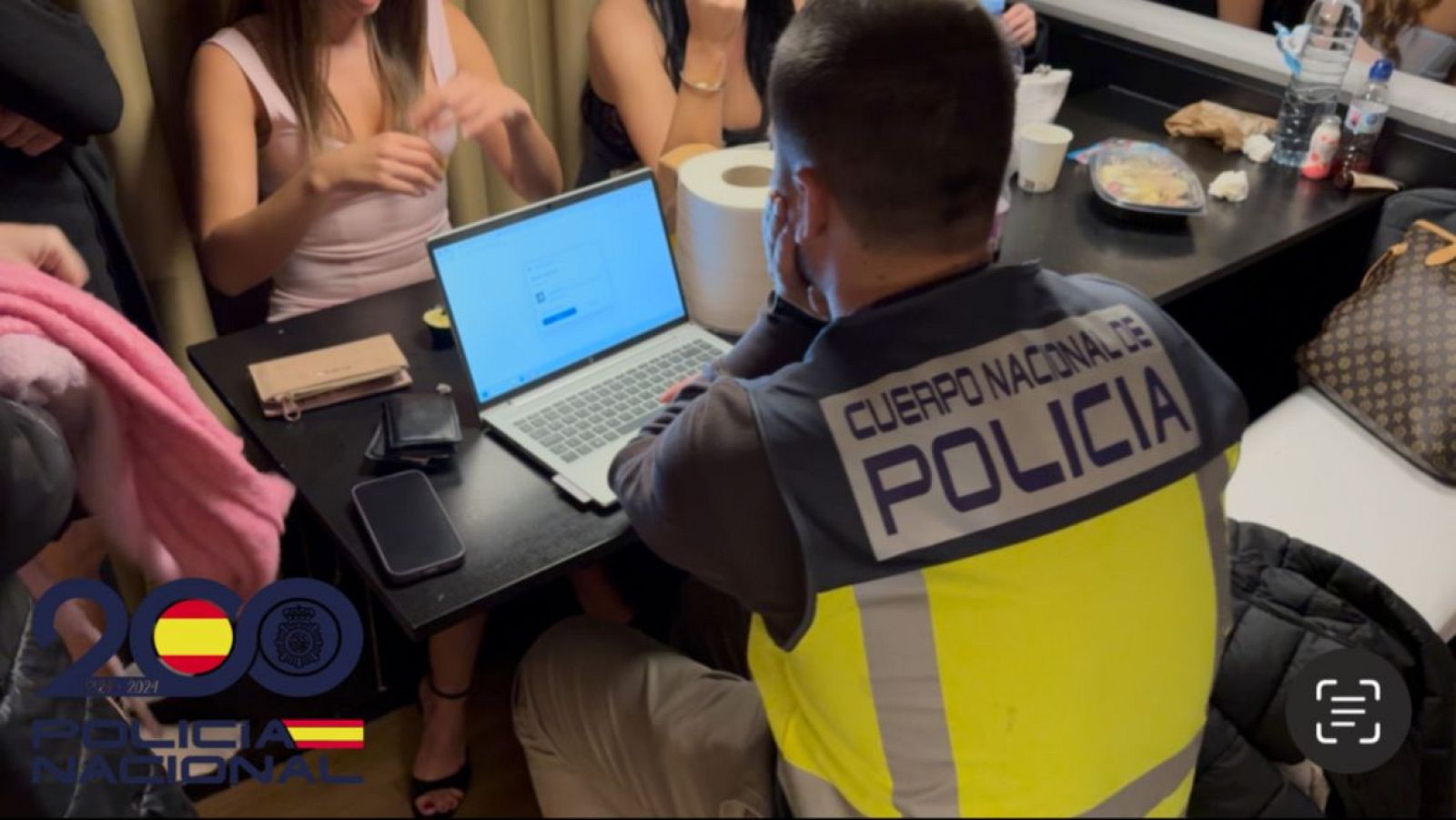 Agente de la Policía Nacional, en uno de los domicilios registrados, con las víctimas