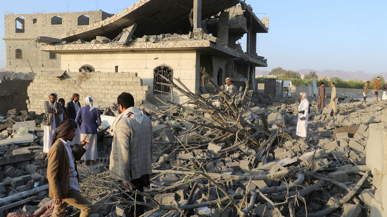 Varias personas sobre los escombros de una casa destruida por un ataque estadounidense en Saada, Yemen