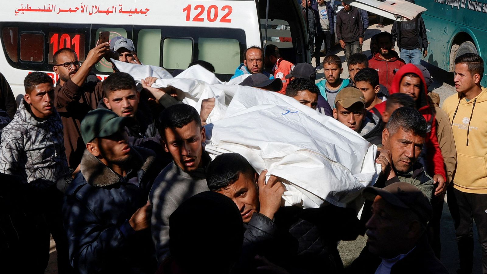 Un grupo de personas transporta el cadáver de un palestino muerto en ataques israelíes en el hospital Nasser de Jan Yunis, en el sur de la Franja de Gaza