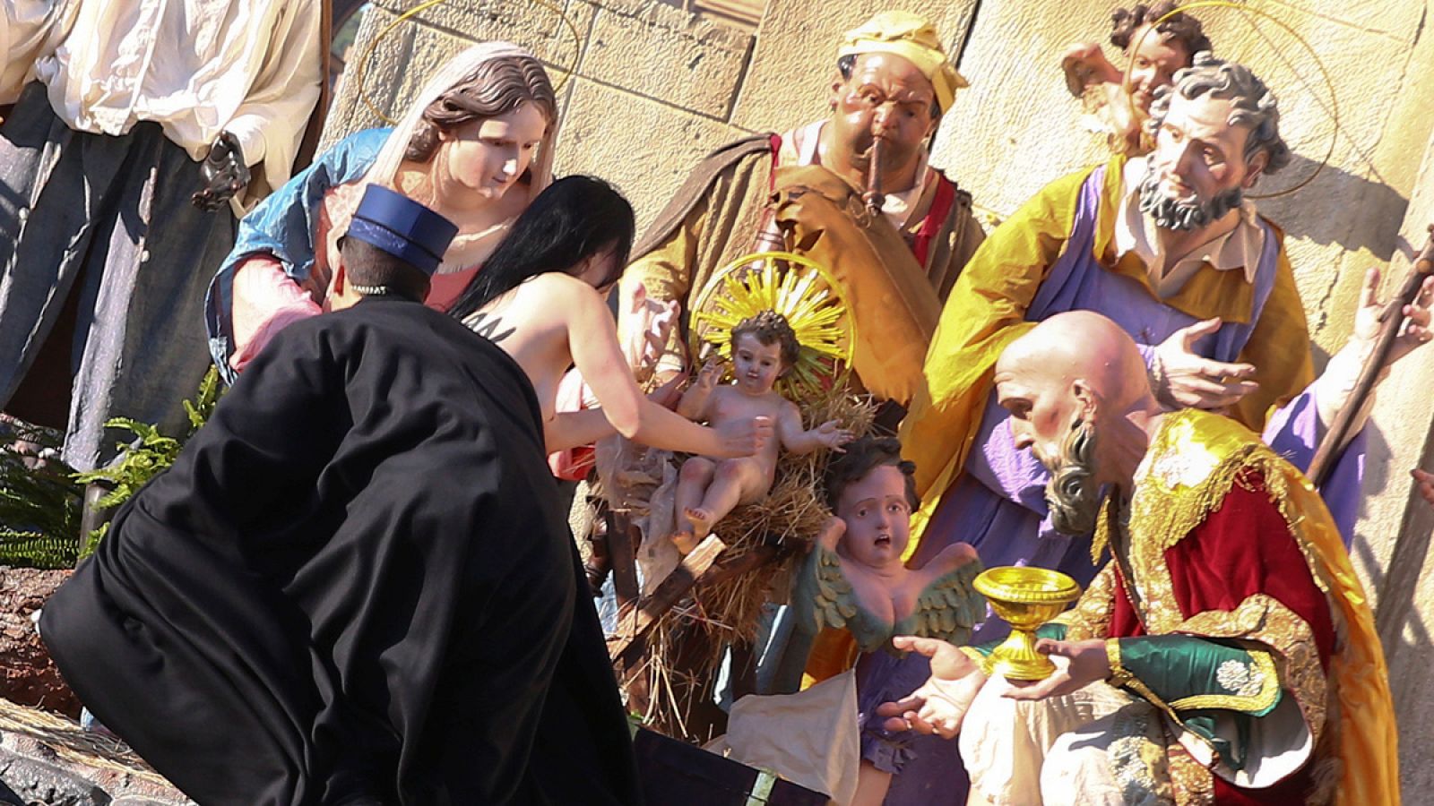 Una activista de Femen intenta llevarse la figura del niño Jesus del belén del Vatino