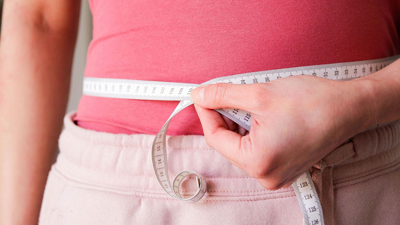 Una mujer se pasa un metro por el abdomen