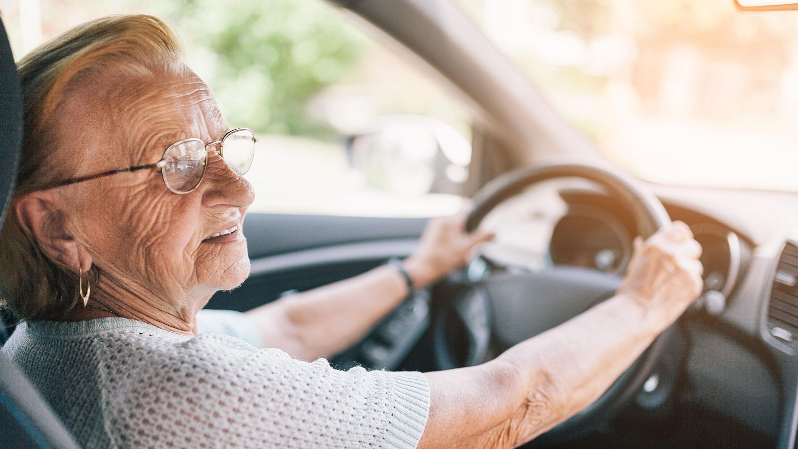 Una anciana conduce relajada un automóvil