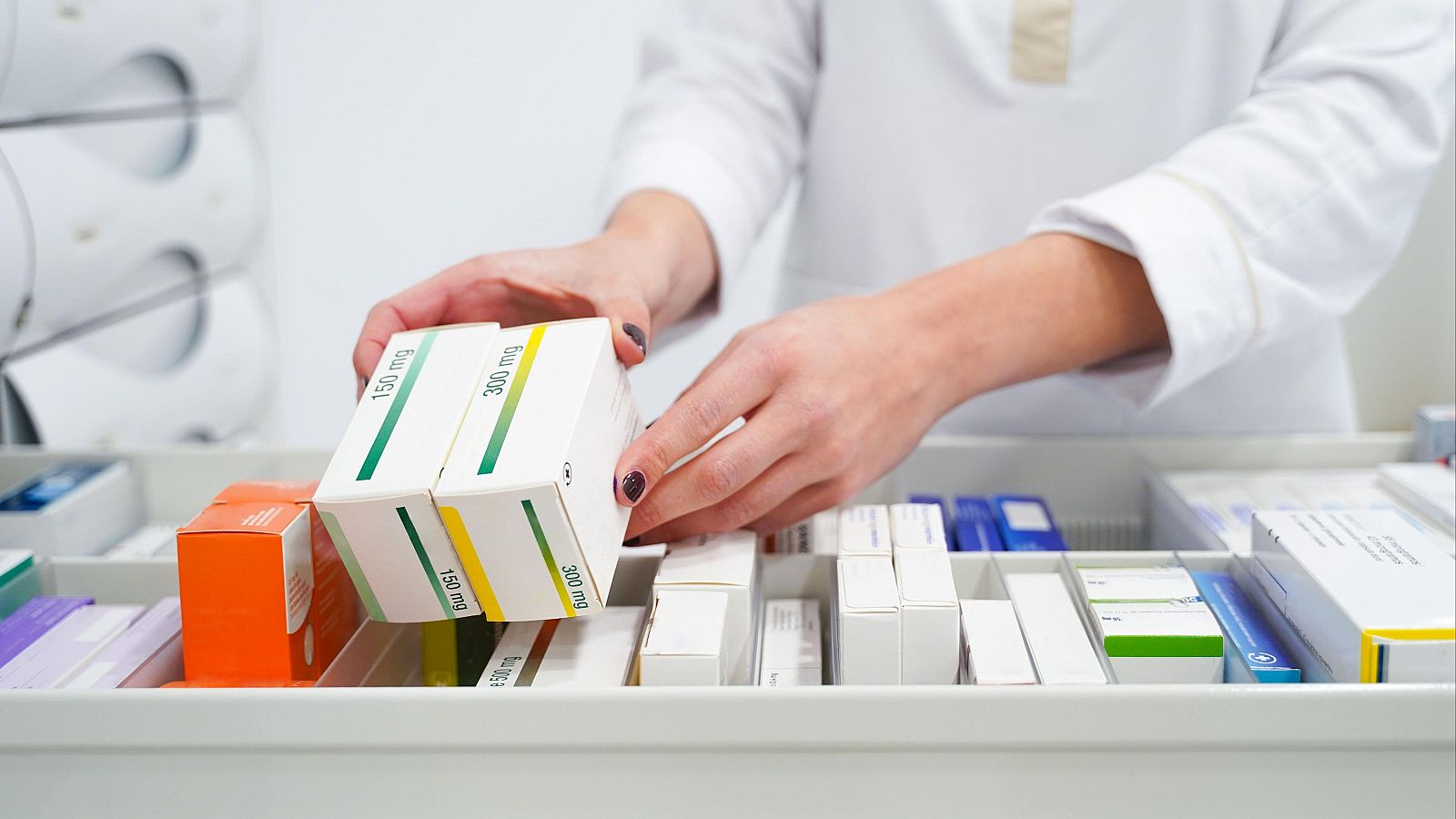 Una persona ordena cajas de medicamentos en una imagen de archivo