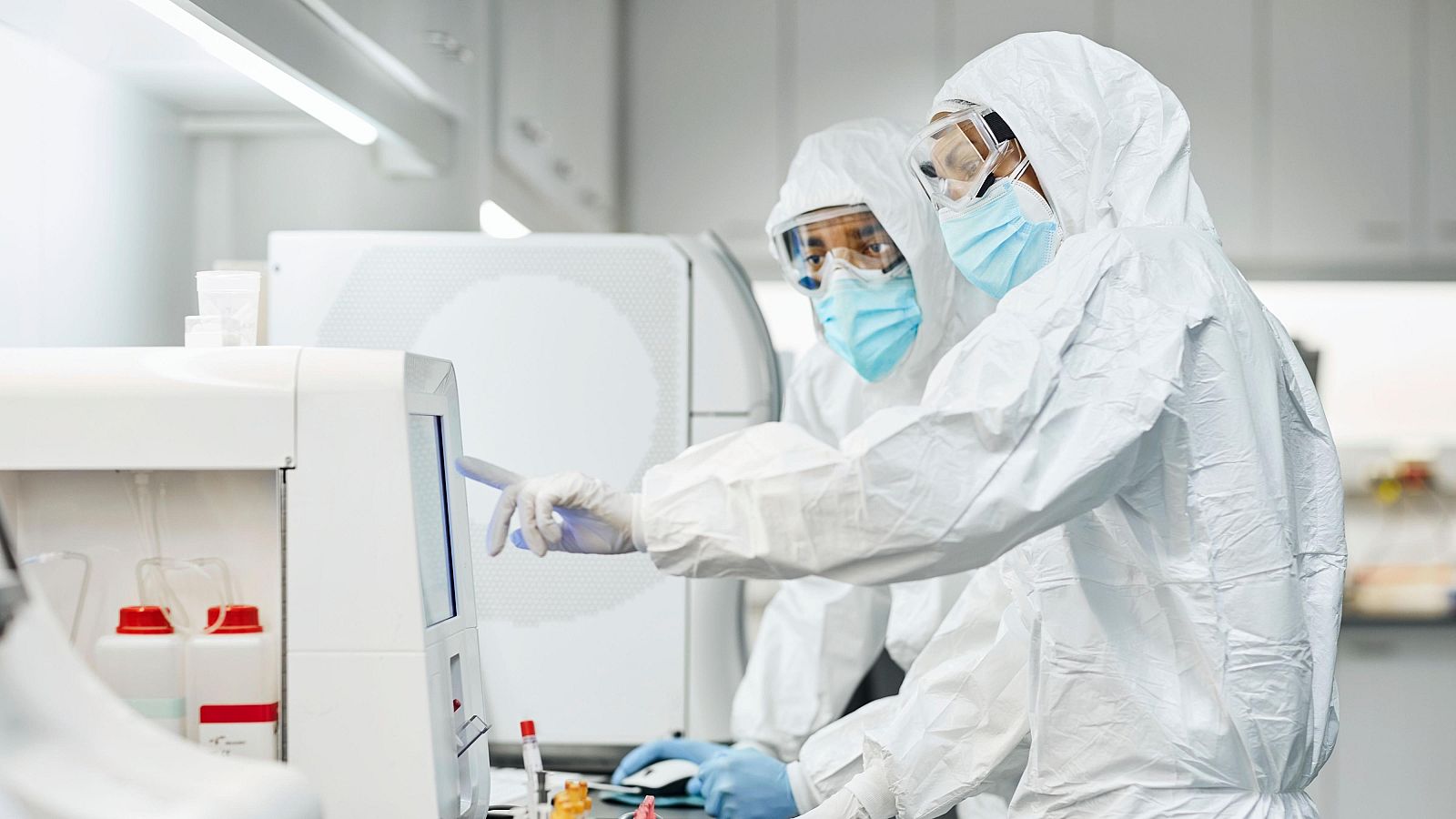 Dos sanitarios con trajes de protección trabajando en un laboratorio