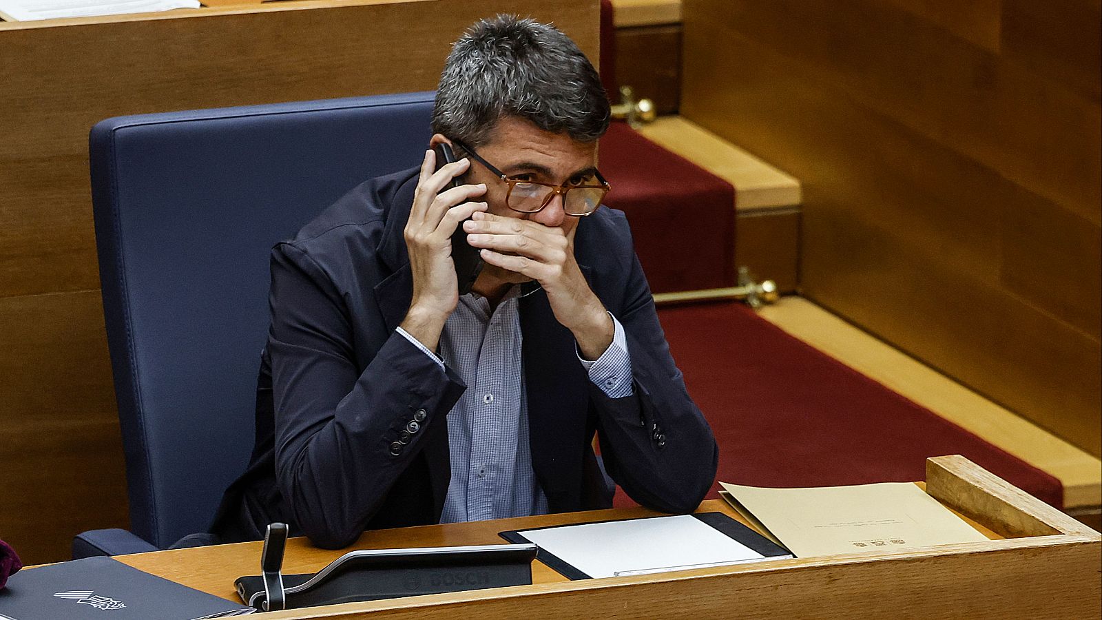 El 'president' de la Generalitat, Carlos Mazón, habla por teléfono en un Pleno en Les Corts