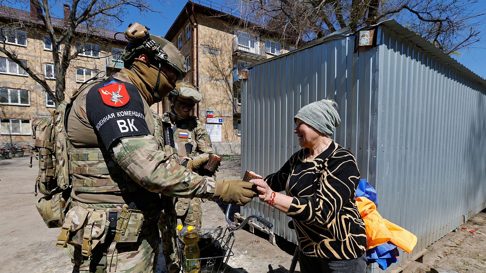 Guerra en Ucrania: Una mujer recibe un dulce tradicional de la Pascua ortodoxa de manos de un soldado ruso en la ciudad de Avdivka