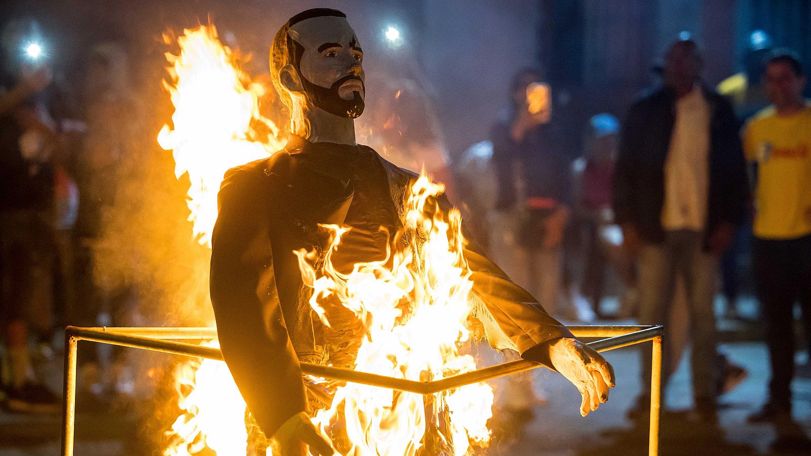 Varias personas queman un muñeco de Bukele durante la tradicional Quema de Judas, en Caracas (Venezuela).