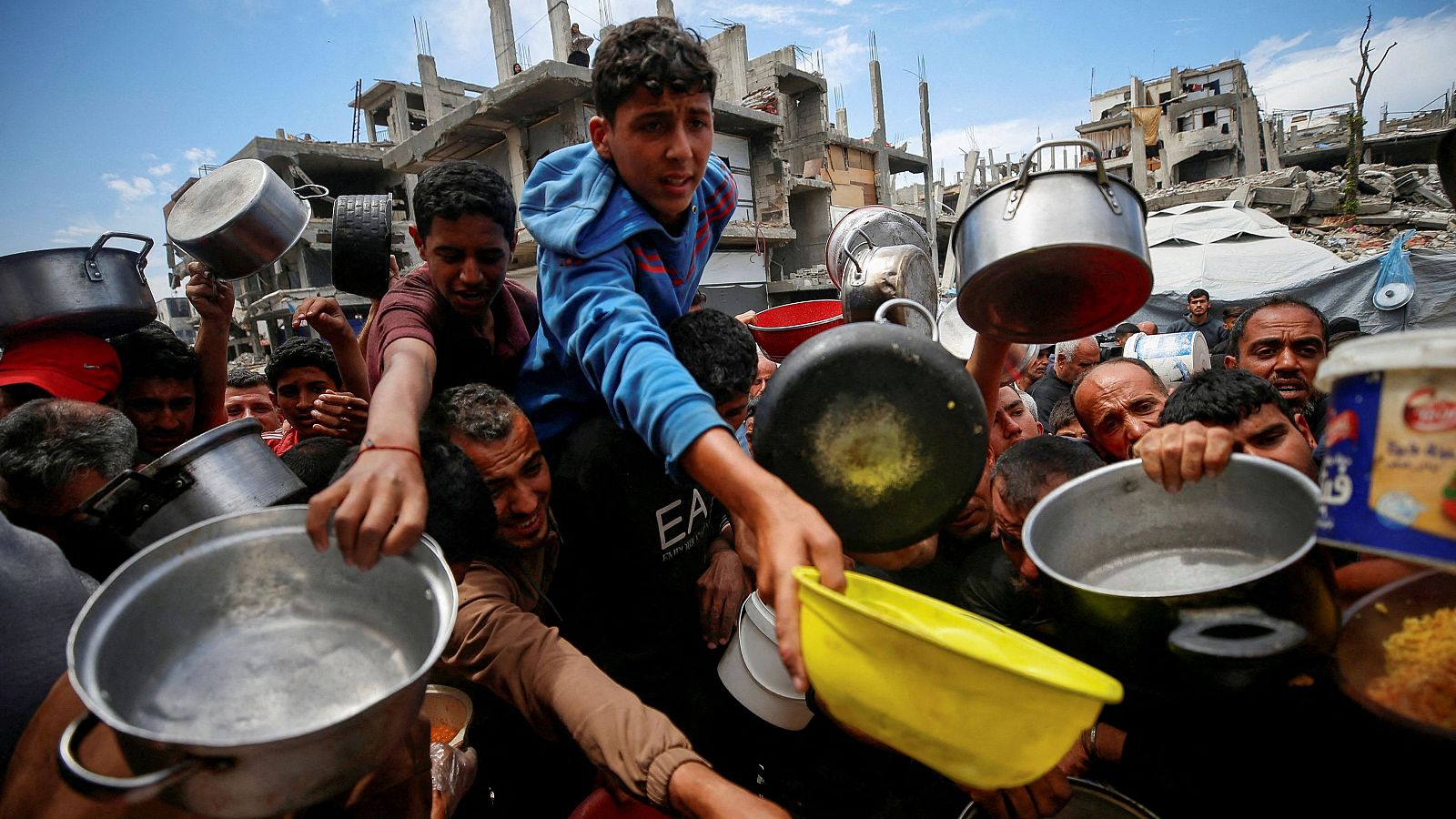 Palestinos esperan para recibir alimentos cocinados por una cocina de caridad, en Beit Lahiya, norte de la Franja de Gaza, 28 de abril de 2025.