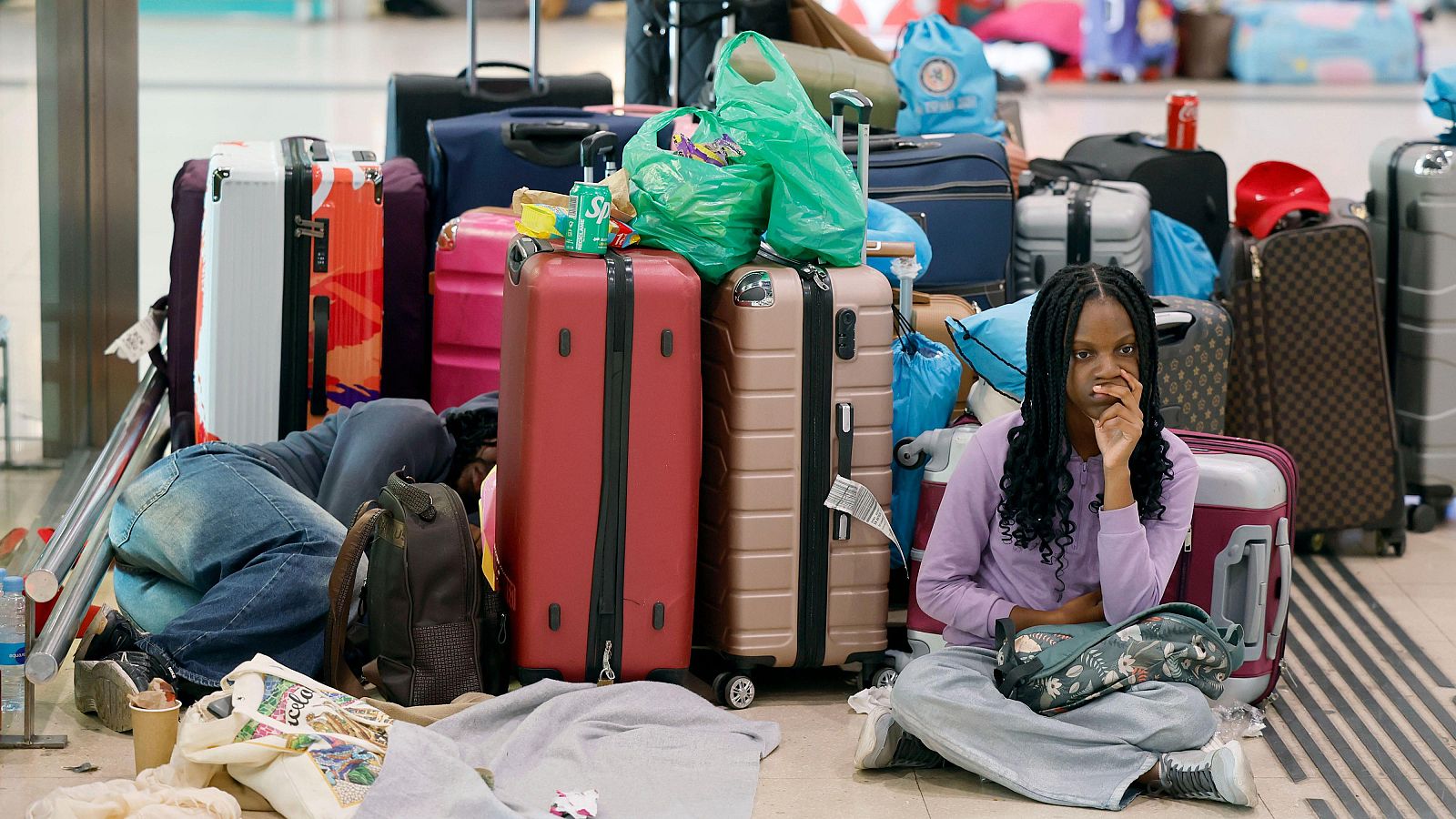 Pasajeros esperan en la estación de Sants, Barcelona, a que reanuden la actividad ferroviaria tras pasar la noche en la estación.