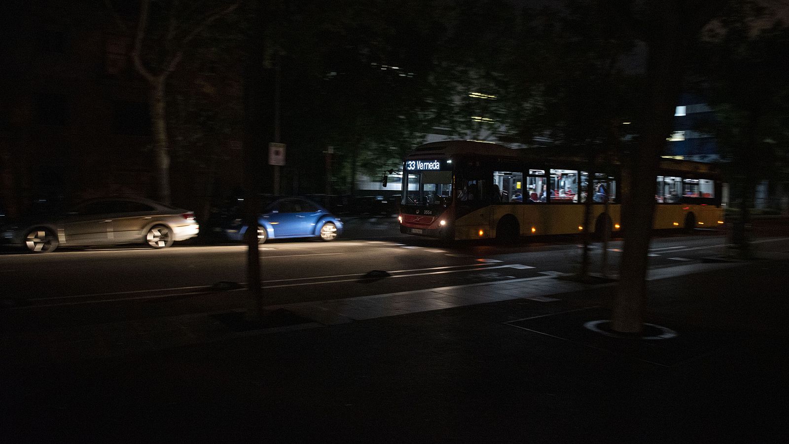 Un autobús de la línia 33 circula a les fosques pels carrers de Barcelona el dia de l'apagada general del 28 de abril