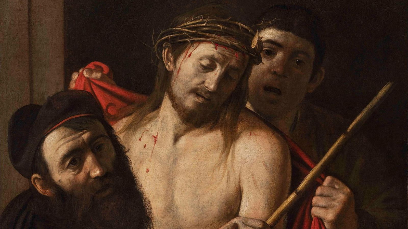 Jesús, con corona de espinas y heridas de sangre, es presentado por un hombre joven con una vara a otro con turbante oscuro. Detalle del 'Ecce Homo' de Caravaggio.