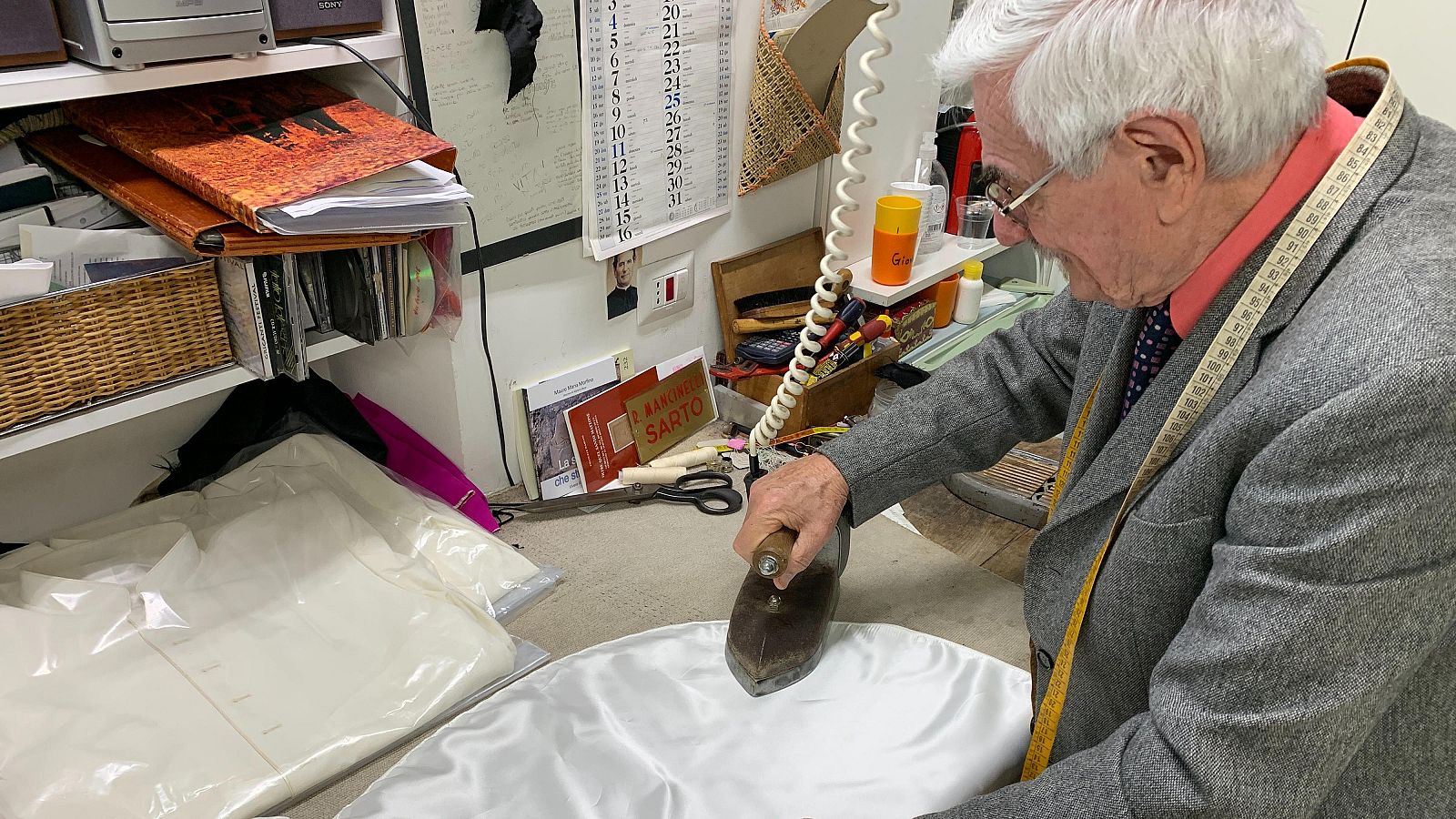 Raniero Mancinelli, de 86 años, plancha una sotana en su tienda junto al Vaticano