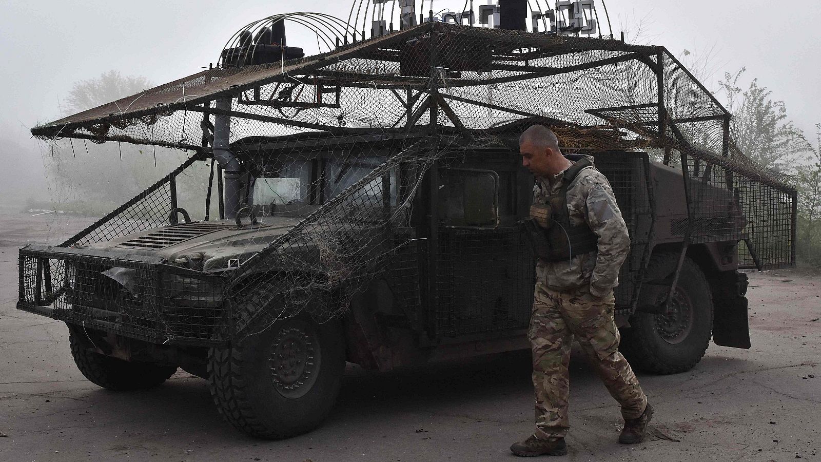 Un militar ucraniano pasa junto a un vehículo militar en un lugar no revelado del frente en la región de Zaporiyia