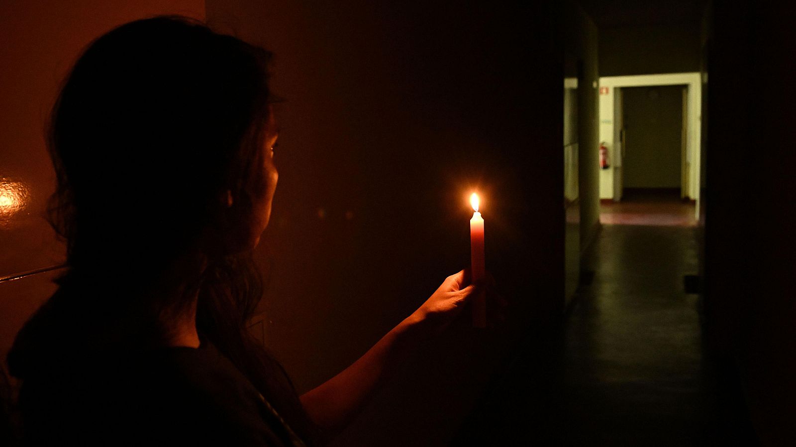Una mujer con una vela durante el día del apagón