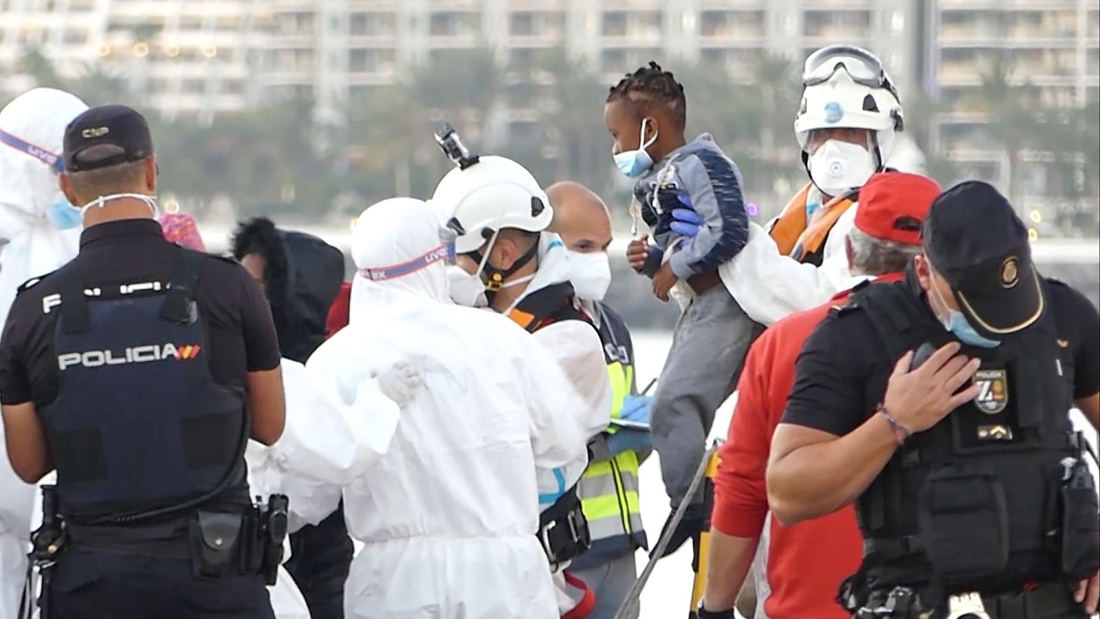 Miembros de la Cruz Roja ayudan a un niño migrante a bajar del barco, en el puerto de Arguineguín, el 17 de marzo de 2021