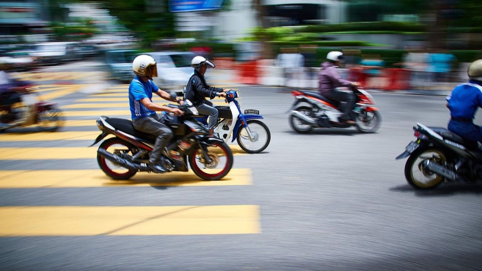 Motoristas ciruclan por una via urbana
