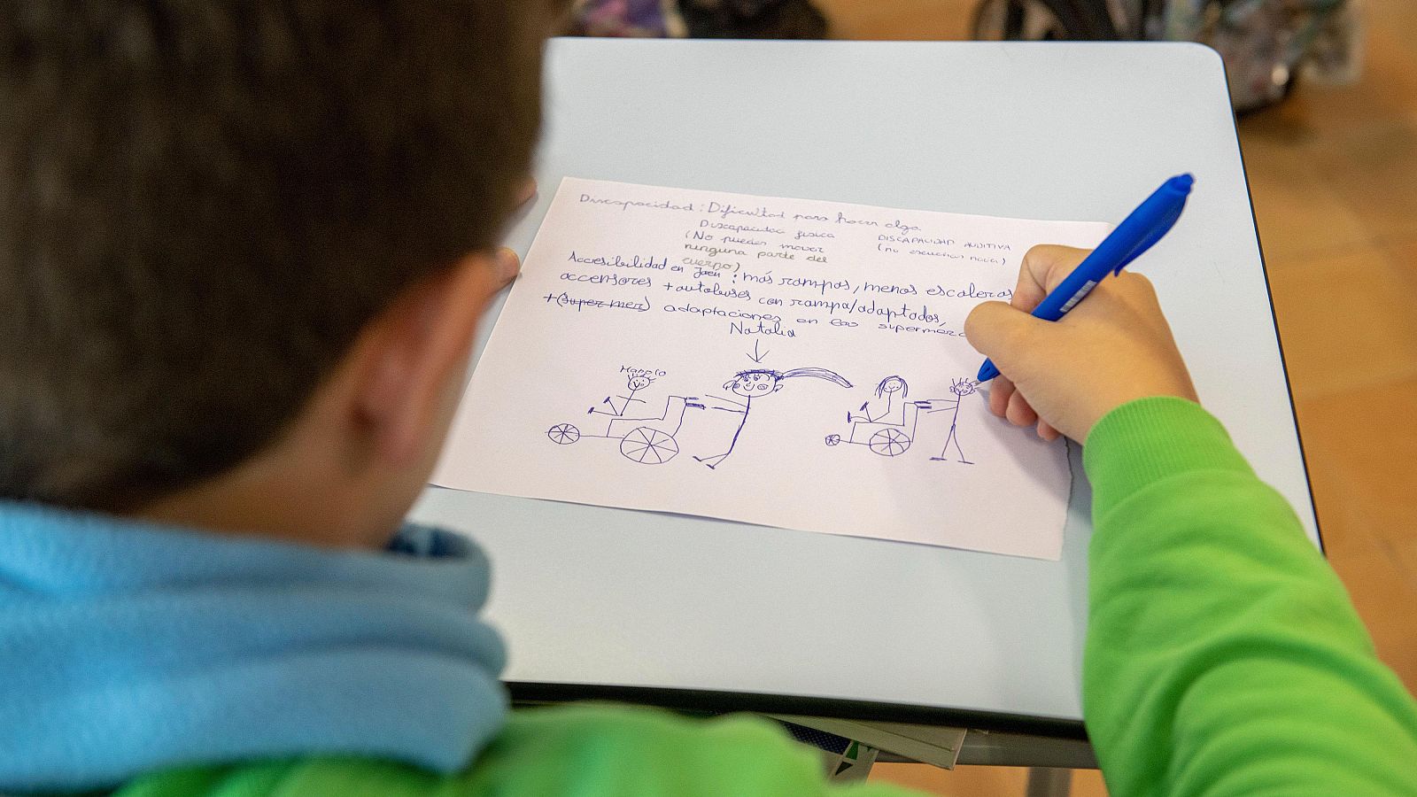 Un niño dibuja a niños con problemas de movilidad en los talleres para entender la diversidad de otros niños