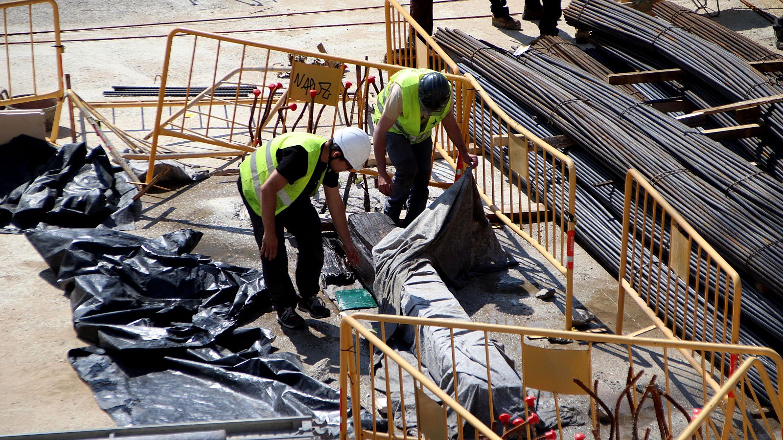 Dos treballadors destapen la quilla, protegida amb lones | ACN