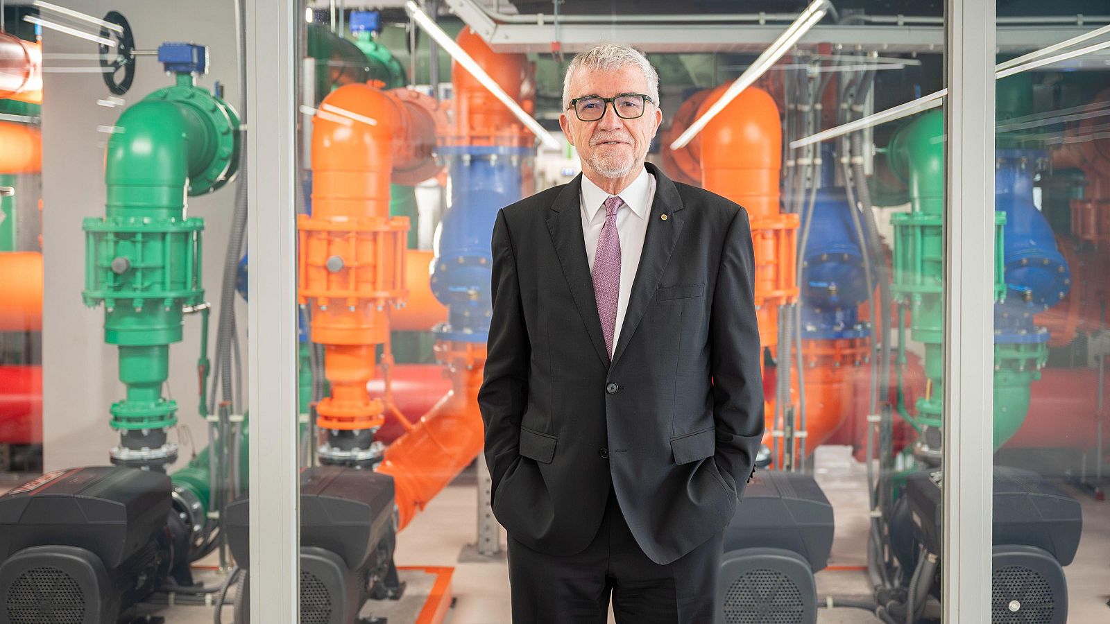 Mateo Valero davant d'uns tubs i maquinària de colors