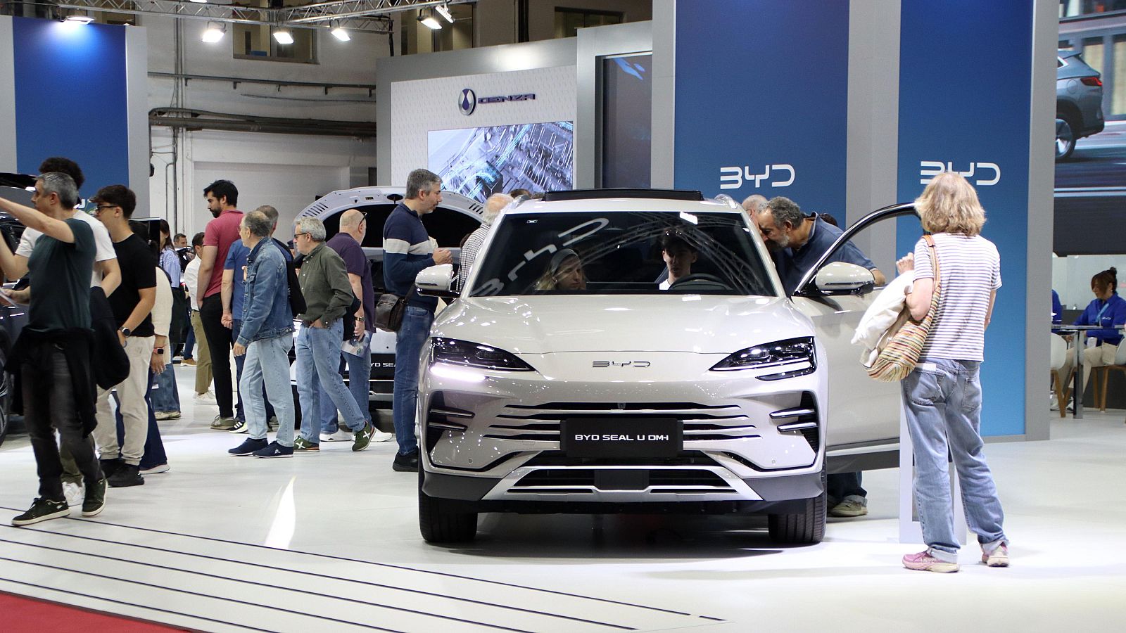 Visitants de l'Automobile pugen a un dels cotxes dels expositors