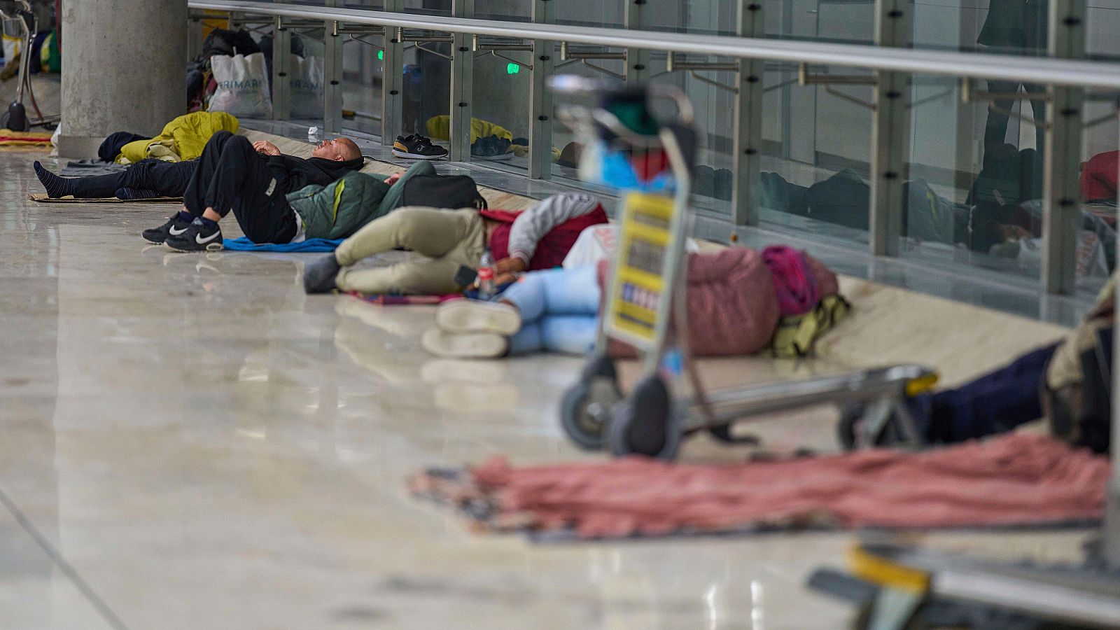 Personas sin hogar duermen en el suelo de la Terminal 4 de Madrid Barajas