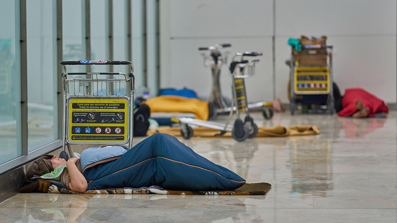 Personas sin hogar duermen en el aeropuerto de Barajas