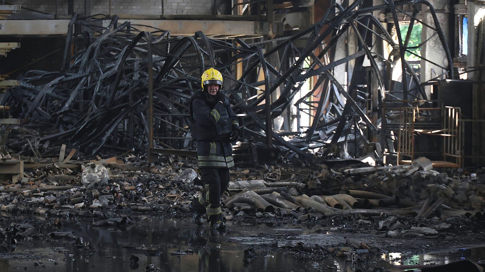 Un bombero del Servicio Estatal de Emergencias extingue un incendio en un local dañado por un ataque ruso