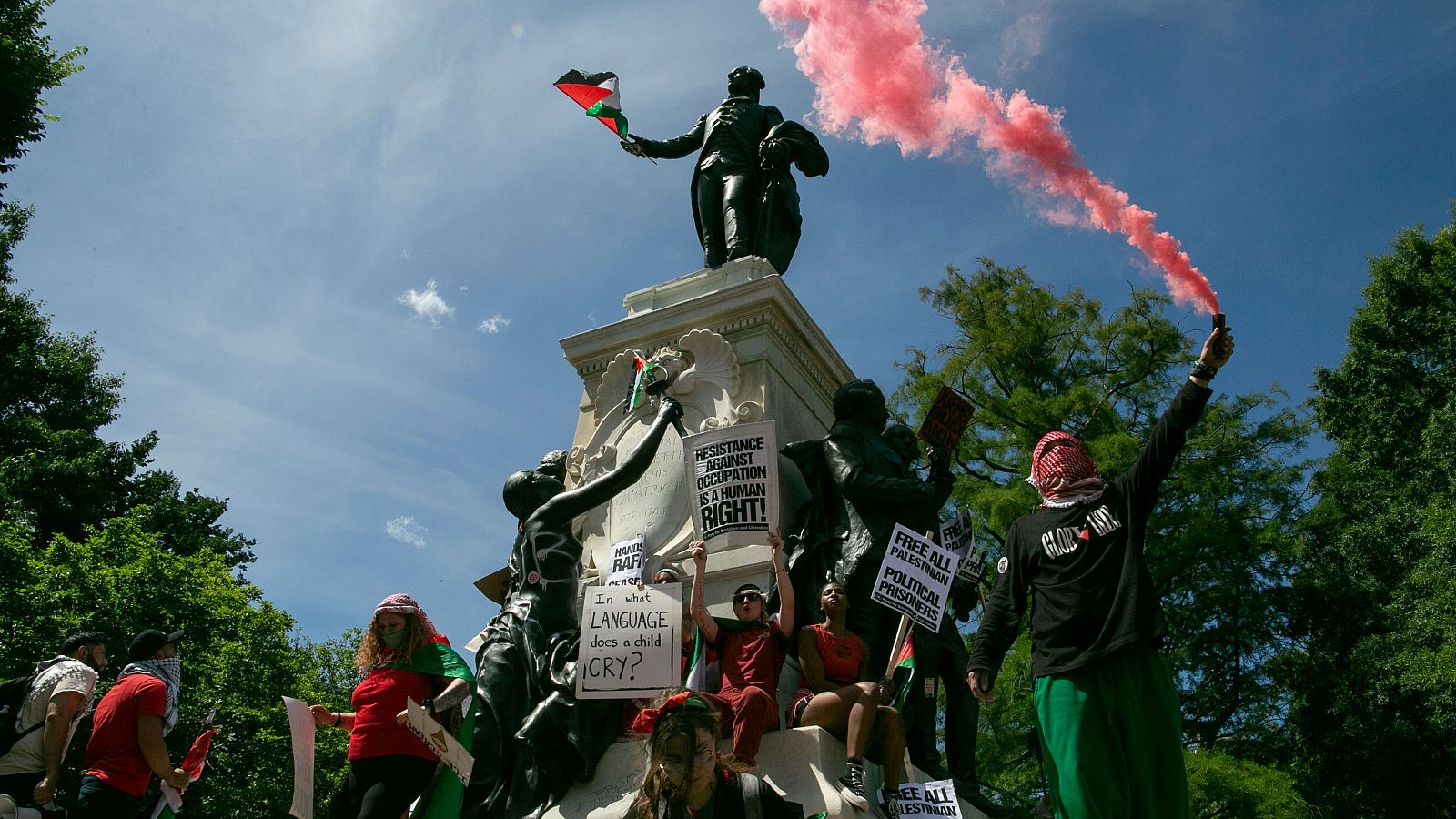 Manifestantes pro-palestinos ondean banderas palestinas en la estatua de Rochambeau, junto a la Casa Blanca