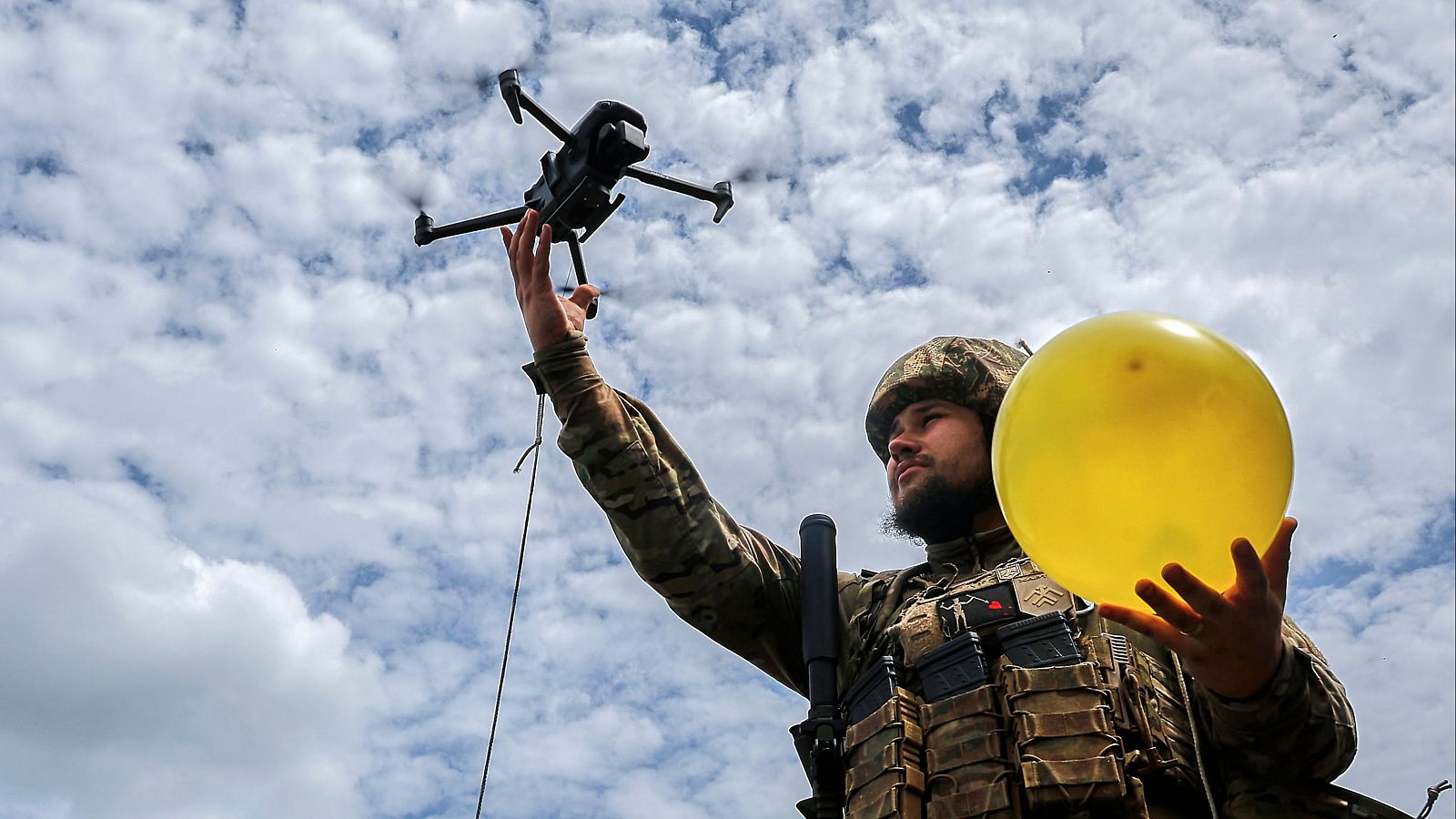 Un militar ucraniano levanta un dron acoplado a un globo para realizar prácticas de tiro durante un entrenamiento antidrones