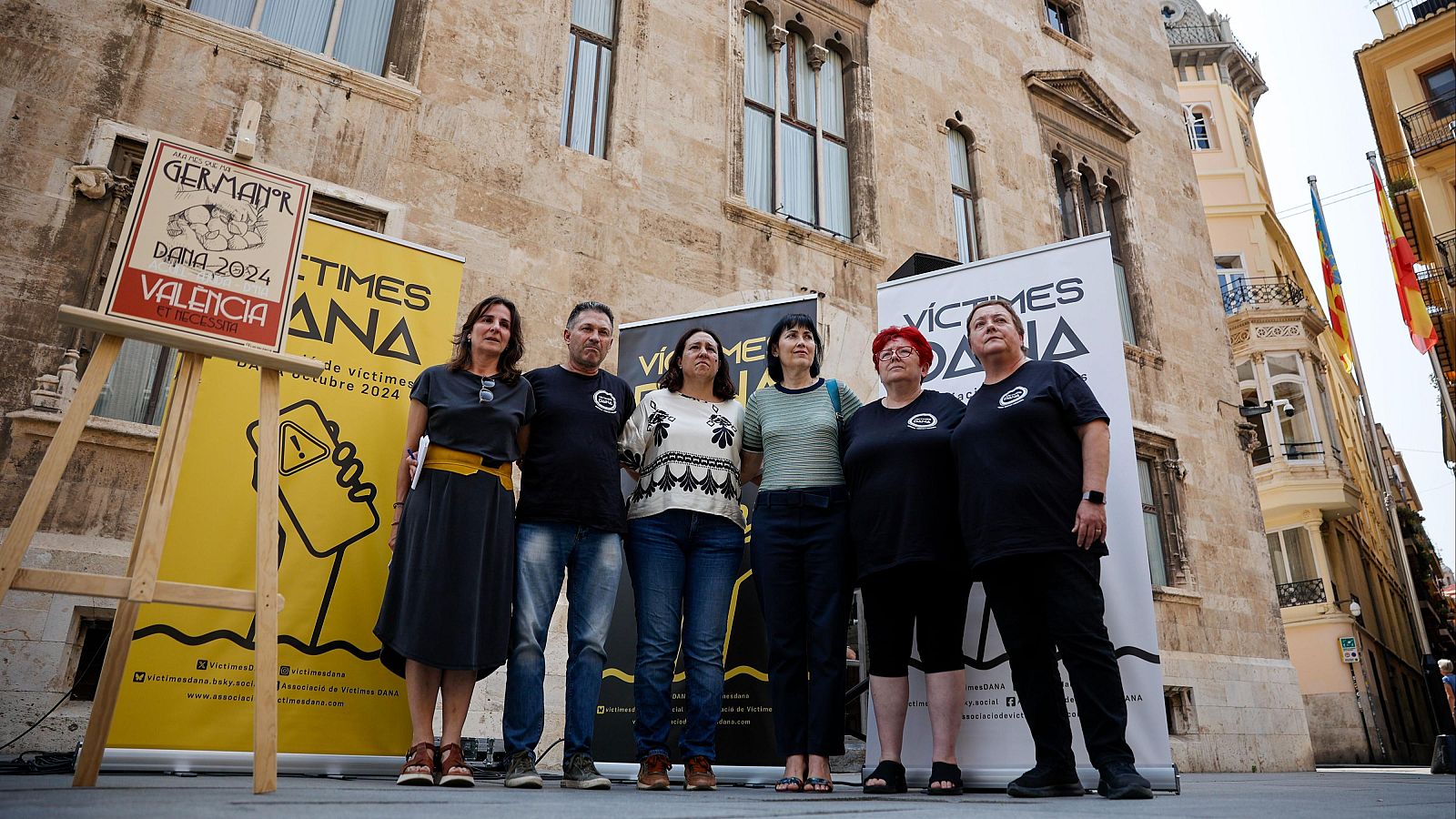 Manifestación ante el Palau de la Generalitat en Valencia.  Siete personas con carteles reclamando justicia por las víctimas de la DANA de octubre de 2024.  Presente Beatriz Garrote.