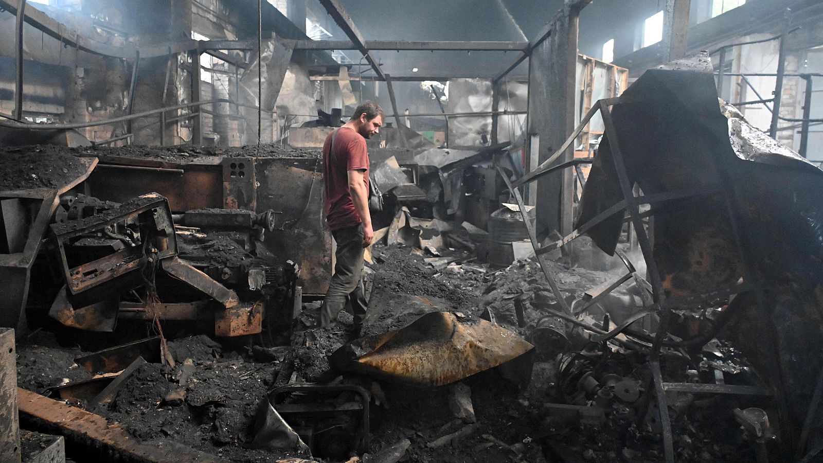 Un ciudadano ucraniano revisa los escombros calcinados de un edificio después de un ataque aéreo ruso